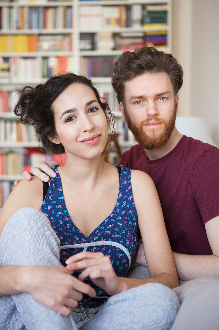 Portrait of young woman with man relaxing at home