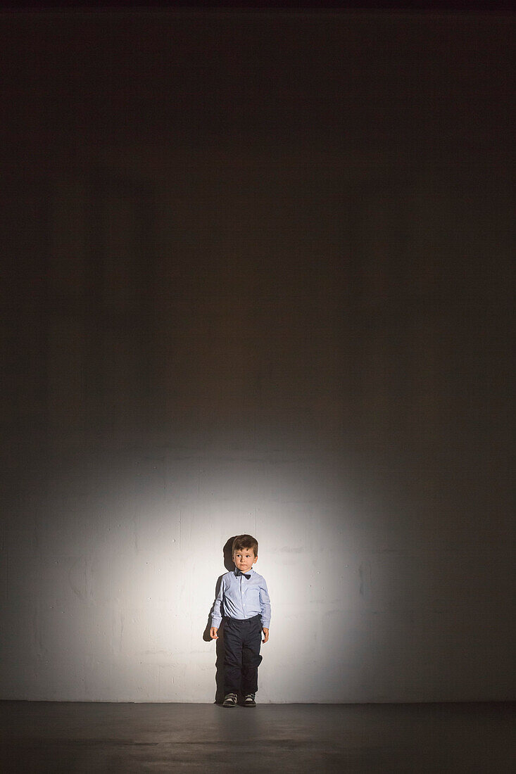 Full length of boy standing against wall