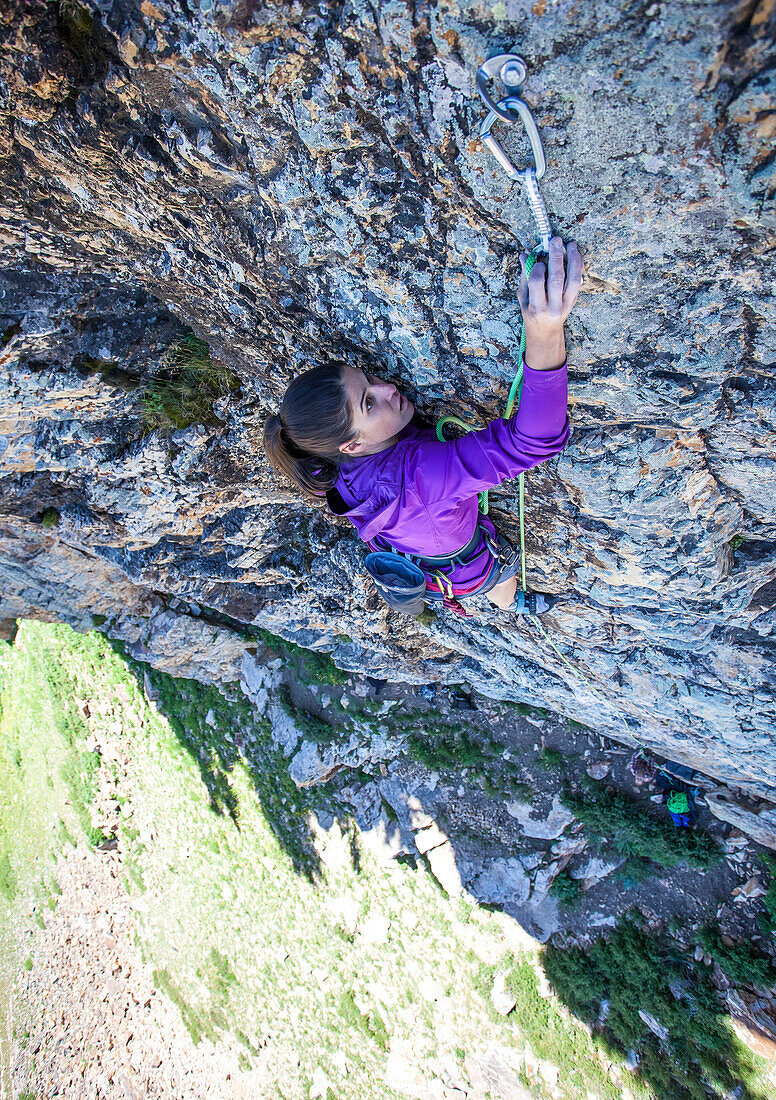 A women clips a quickdraw while lead climbing in Little Cottonwood Canyon, Utah.