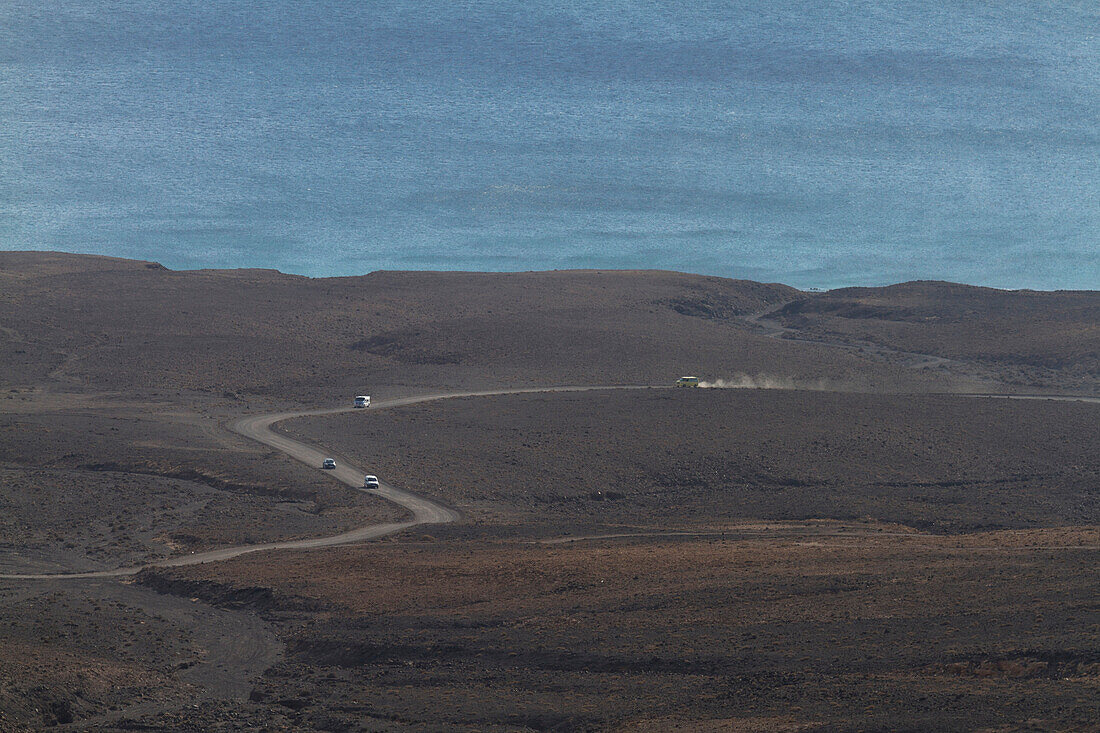 Empty winding road in the middle of a desert and volcanic landscape