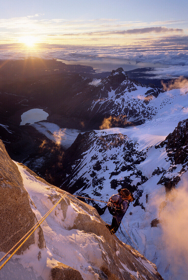 A climber rappels down Cerro Torre's south east ridge at dawn, after an ascent of that peak, in Argentine Patagonia. Cerro Torre is one of the most difficult and iconic peaks in the Southern Andes, and is a highly sought after summit by the worlds top alp