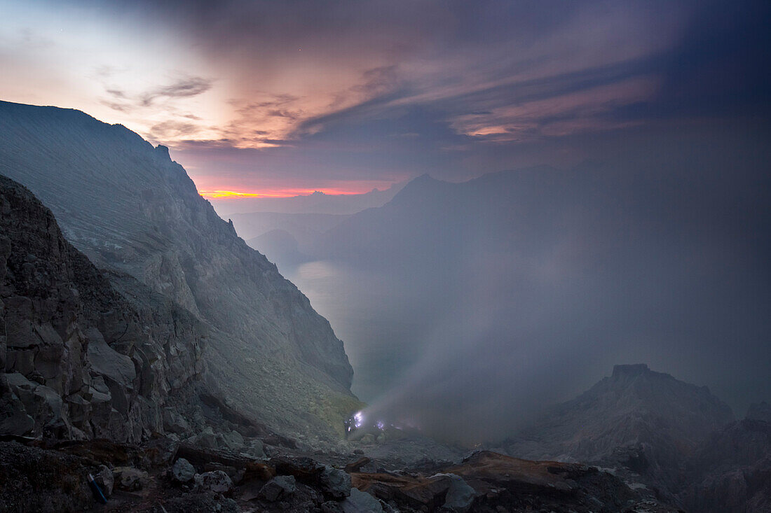 Blue flames of molten sulfur burning at the mine inside the crater of Kawah Ijen volcano, Banyuwangi, Java, Indonesia