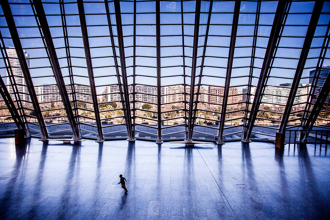 Child running across an empty floor at a museum.