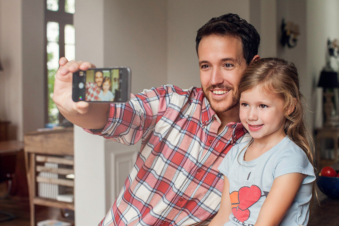 Father posing for selfie with daughter