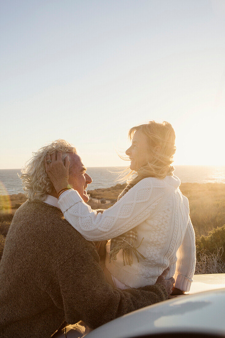 Older Caucasian couple hugging outdoors