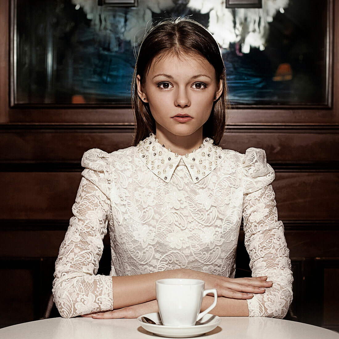 Caucasian teenage girl drinking coffee in restaurant