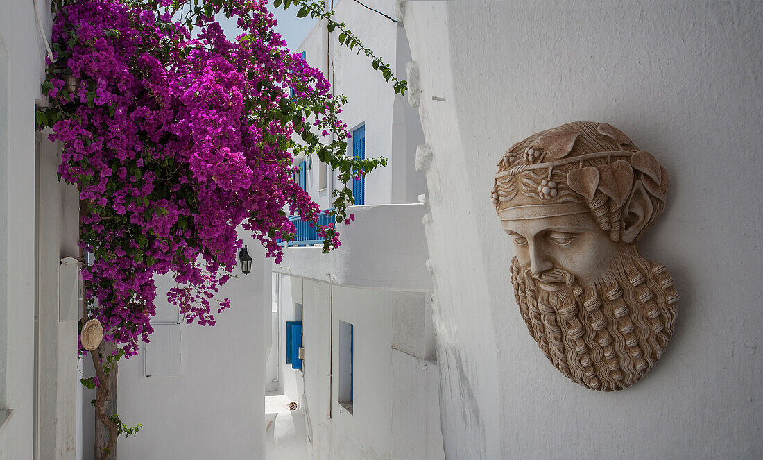 Sculpture and flowers on traditional building exterior