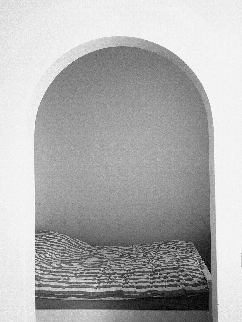 Bed and room seen through an arch
