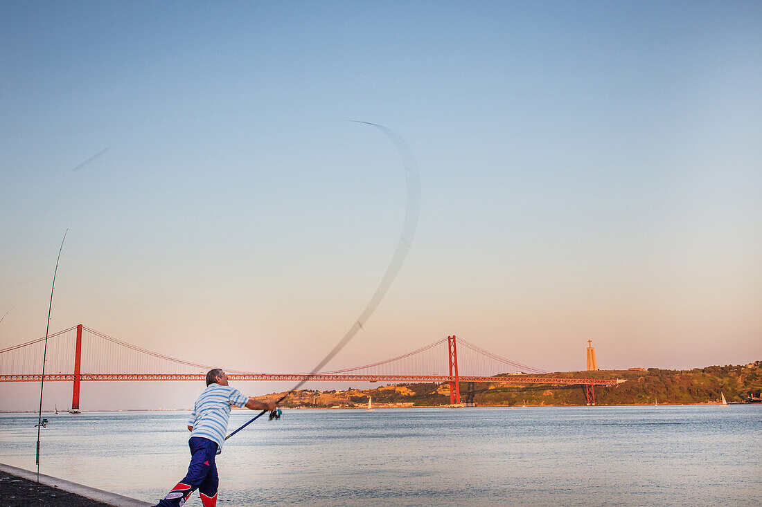 fisherman and the 25th of april bridge, lisbon, portugal, europe