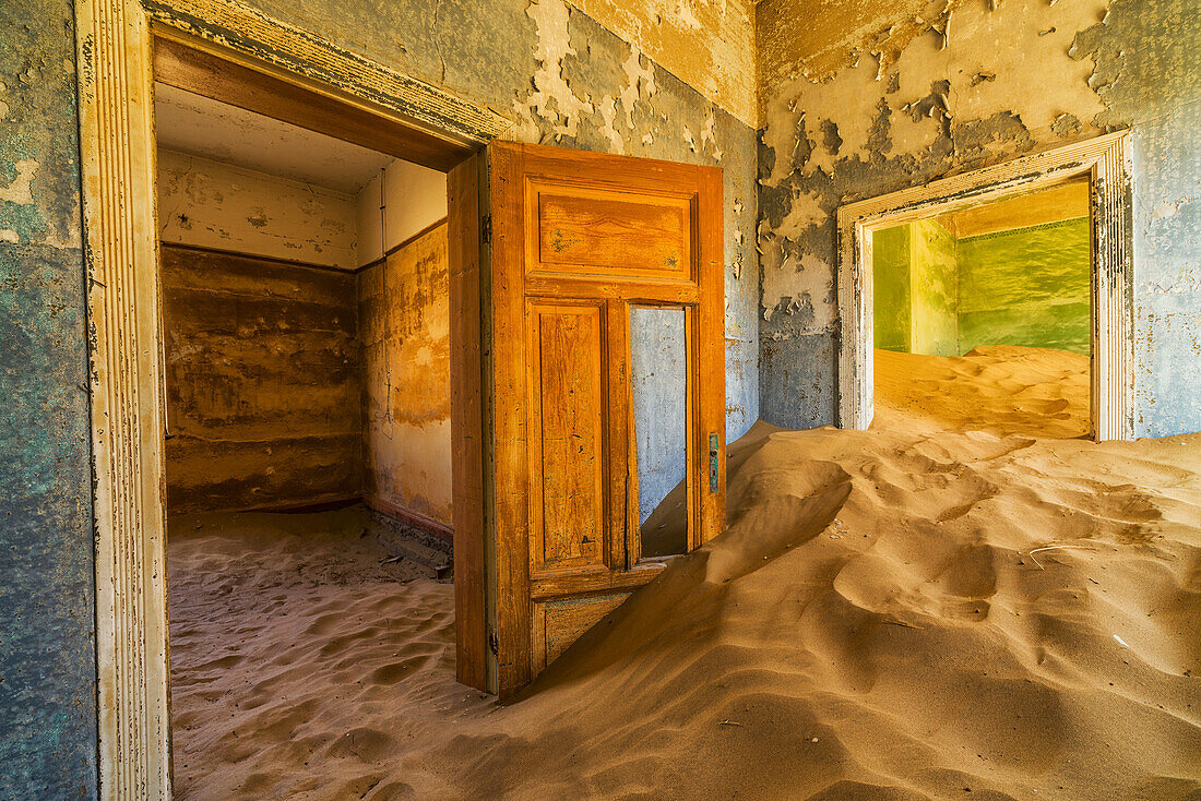 Sand in the rooms of a colourful and abandoned house Kolmanskop, Namibia