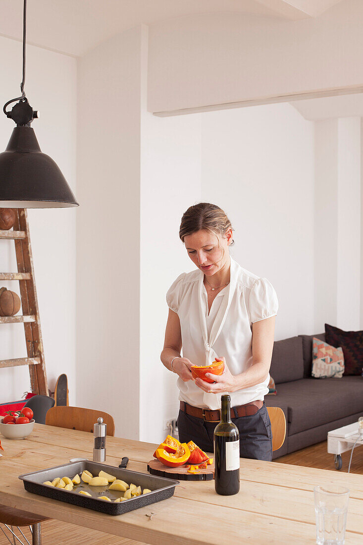 Woman cutting pumpkin at home