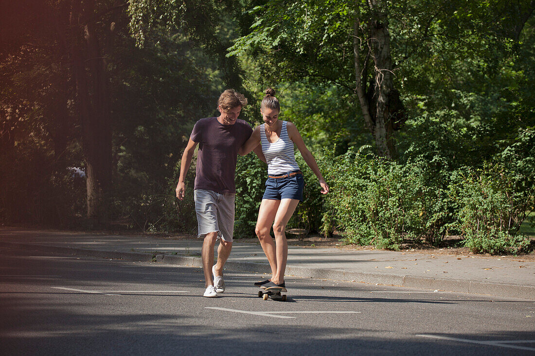 Young man helping woman to skating