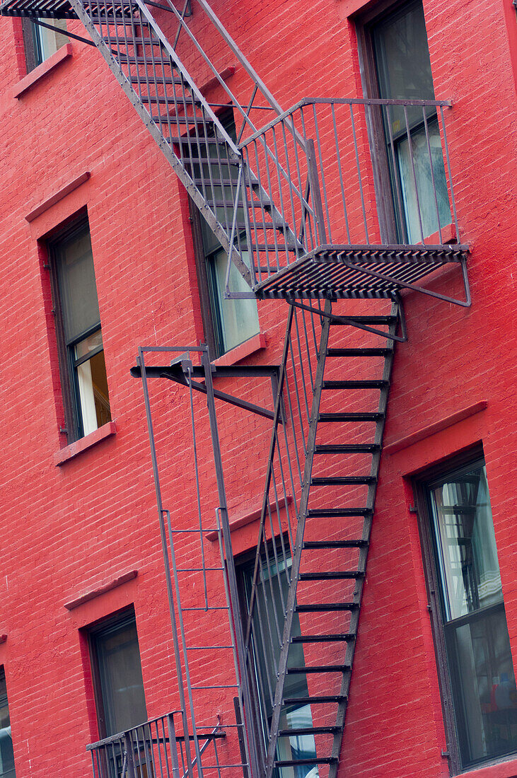 Red painted tenement block and fire escapes, New York, United States of America, North America