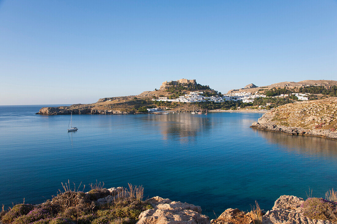 View across the tranquil waters of Lindos Bay, Lindos, Rhodes, Dodecanese Islands, South Aegean, Greece, Europe