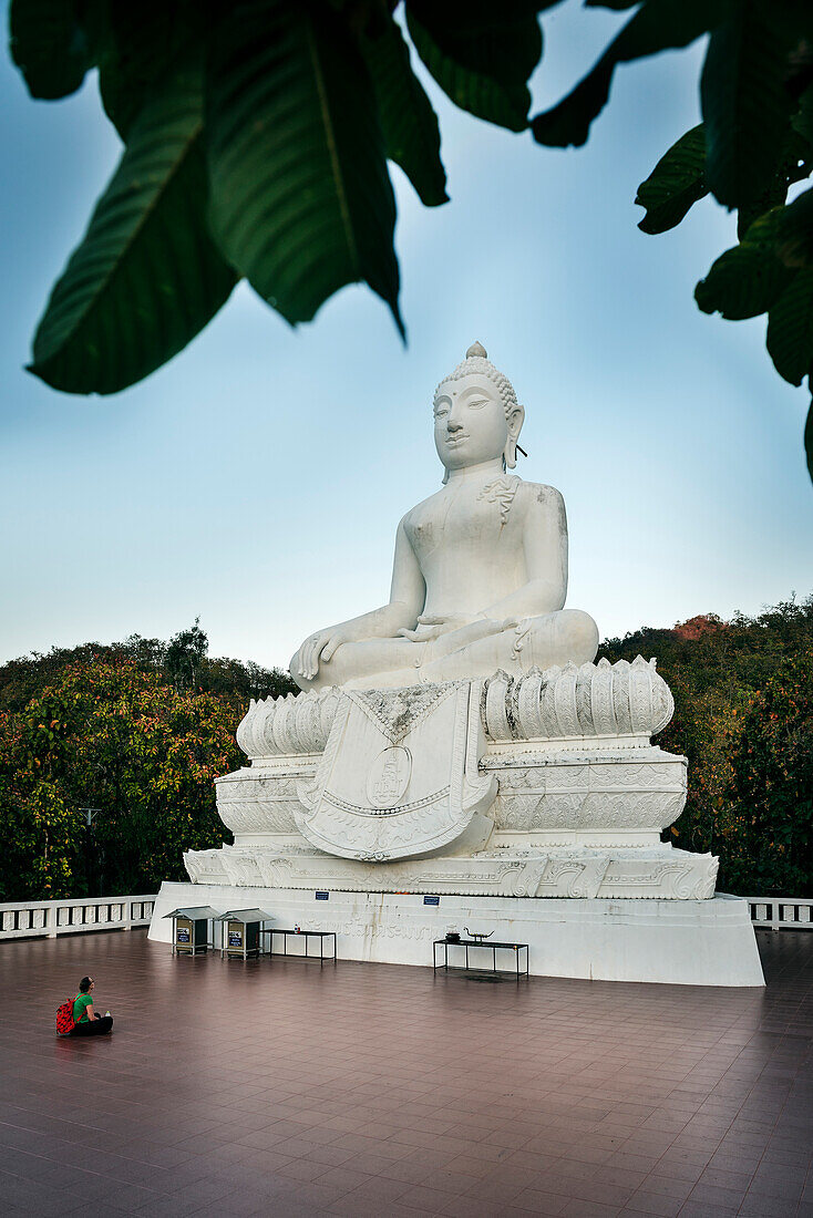 Tourist sitting in front of a giant white Buddha figure, temple Wat Mae Yen, Pai, Thailand, Southeast Asia