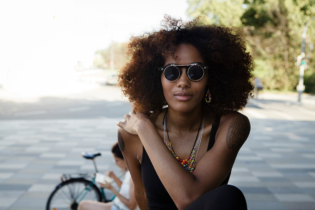 Portrait einer jungen afroamerikanischen Frau mit Sonnenbrille in der Stadt, München, Bayern, Deutschland
