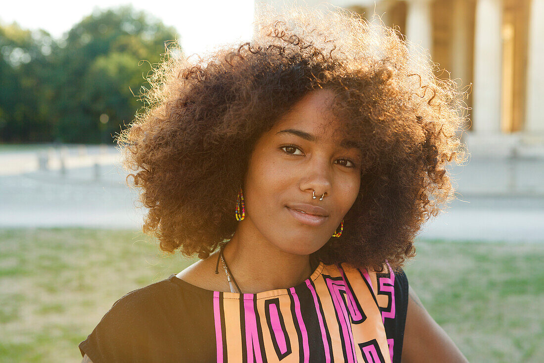 Young afro-american woman in backlight scenery on Koenigsplatz, Munich, Bavaria, Germany