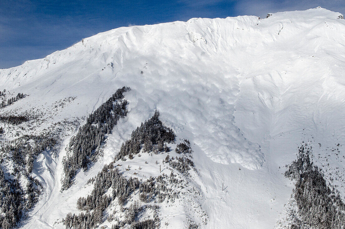 Eine künstlich ausgelöste Katastrophenlawine donnert über das Testgelände des Schweizer WSL-Instituts für Schnee- und Lawinenforschung (SLF) im Vallée de la Sionne, westliche Berner Alpen, Kanton Wallis, Schweiz