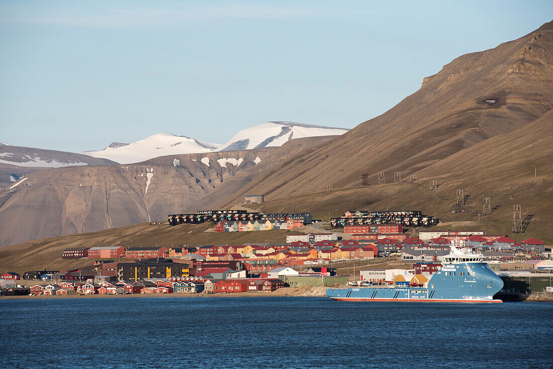 Das Dorf Longyearbyen in der Mitternachtssonne, davor das Wasser des Isfjords, dahinter die nahen Gipfel, Spitzbergen, Svalbard Archipel, Norwegen