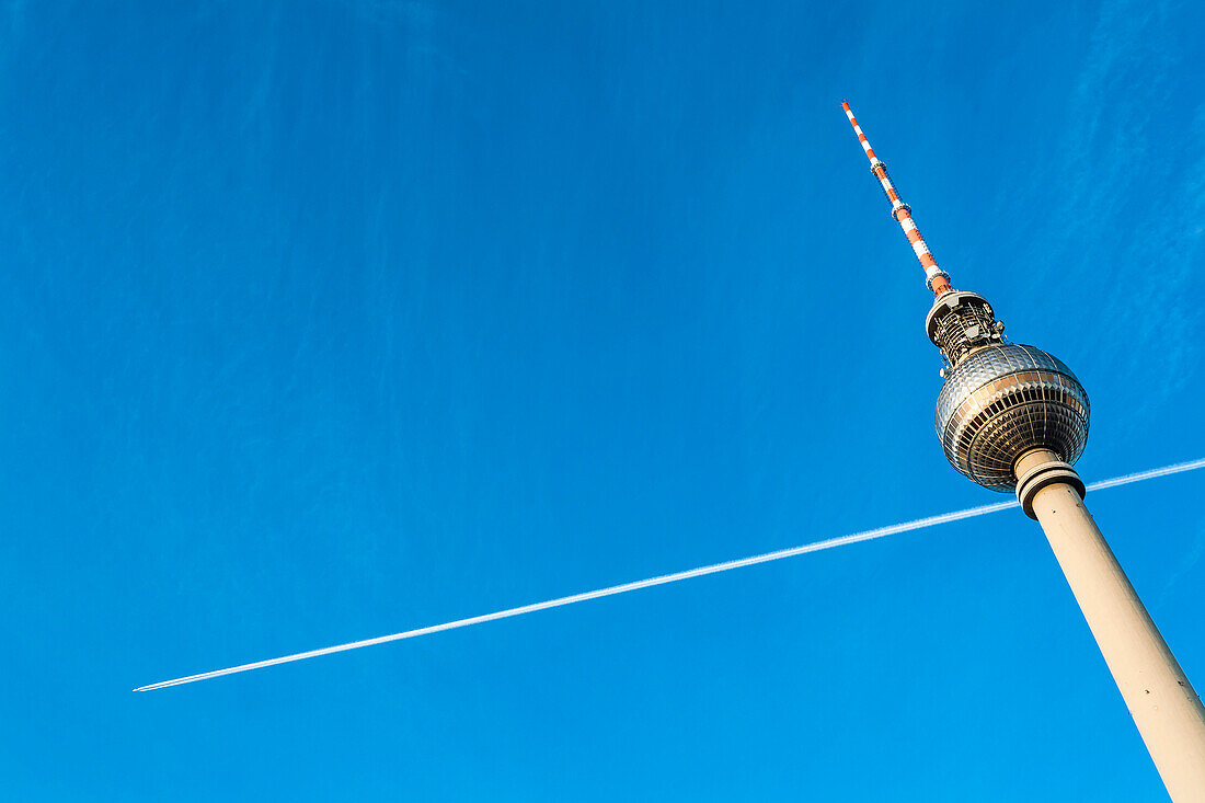 The television tower on the Alexander Platz in East Berlin and an airplane with condensation trail, Berlin, Germany