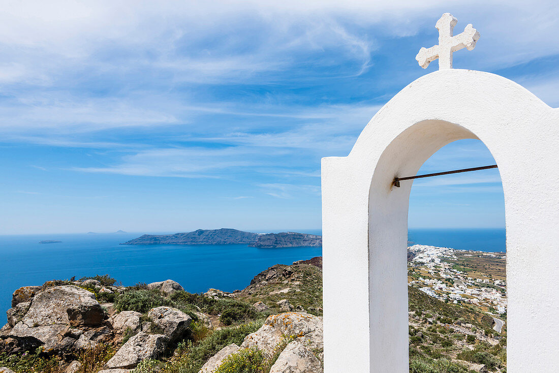 Cross of a Greek orthodox chapel, view at the Mediterranean Sea the neighbouring islands and the village Oia, Santorin, Cyclades, Greece