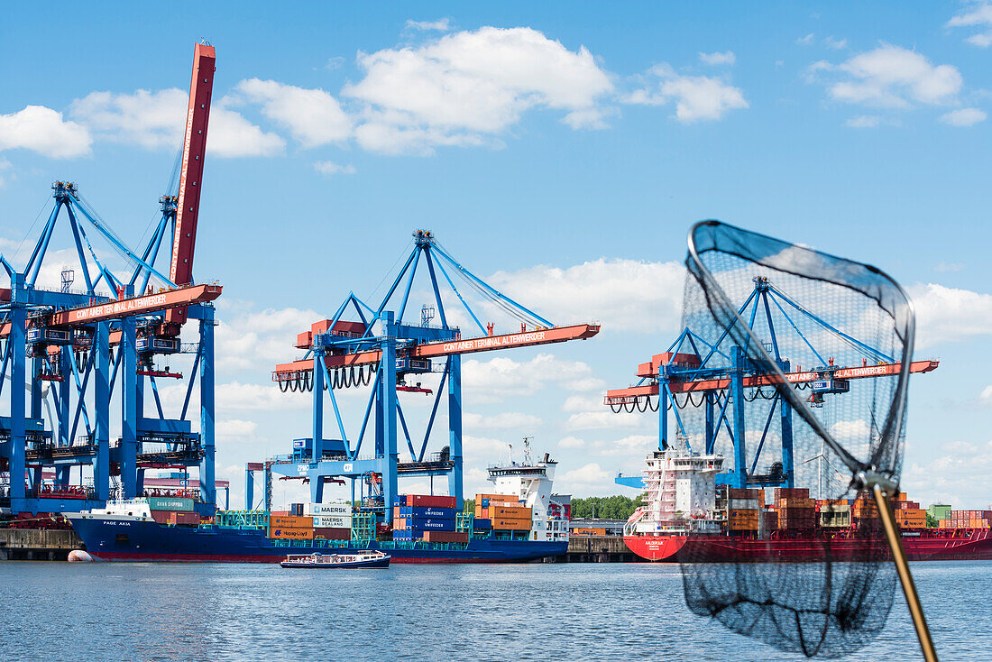 Ships and cranes and a launch during harbour cruise in the harbour container terminal Altenwerder, Hamburg, Germany