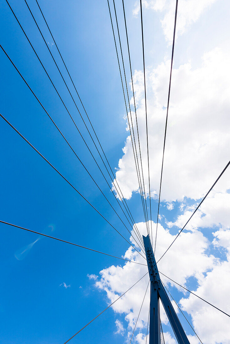 Die fächerförmigen Abspannungen und der Pylon, der in Stahl ausgeführten Schrägseilbrücke Köhlbrandbrücke gegen den blauen Himmel, Hamburg, Deutschland