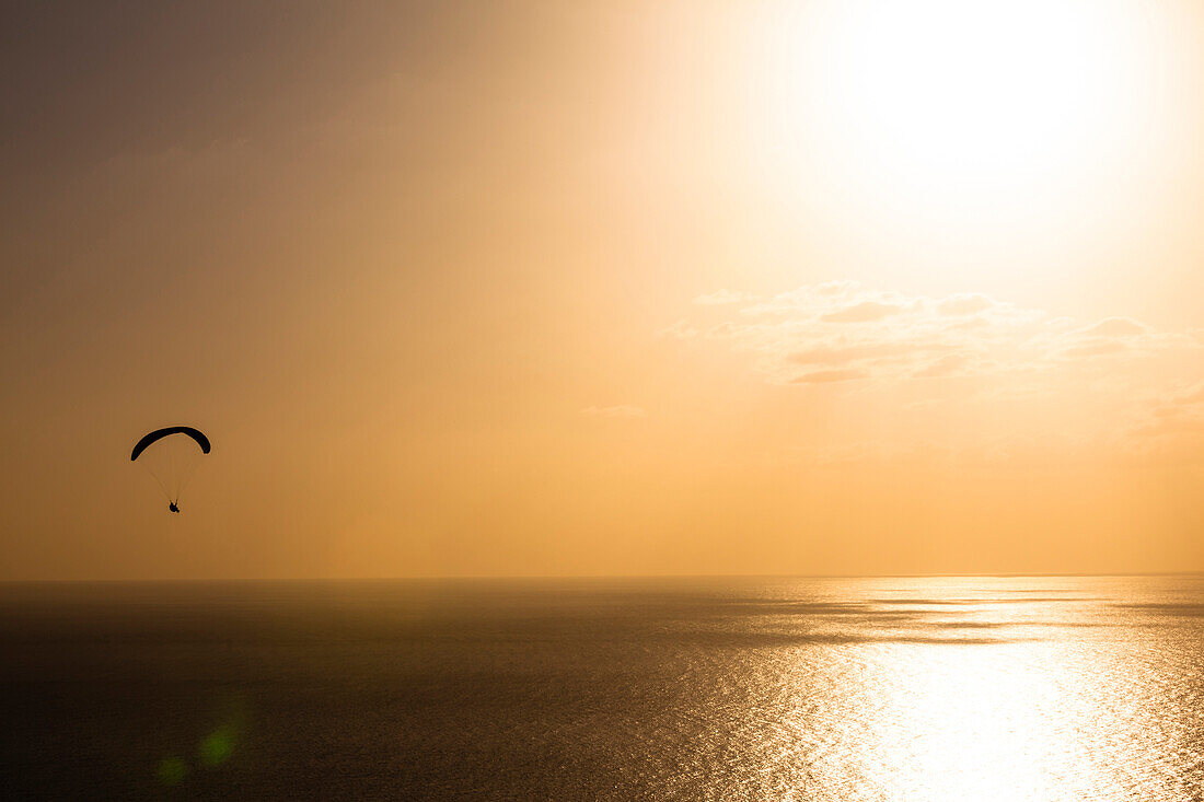 Gleitschirmfliegen über dem Atlantik auf der Westseite der Insel zum Sonnenuntergang, Puerto de Naos, La Palma, Kanarische Inseln, Spanien