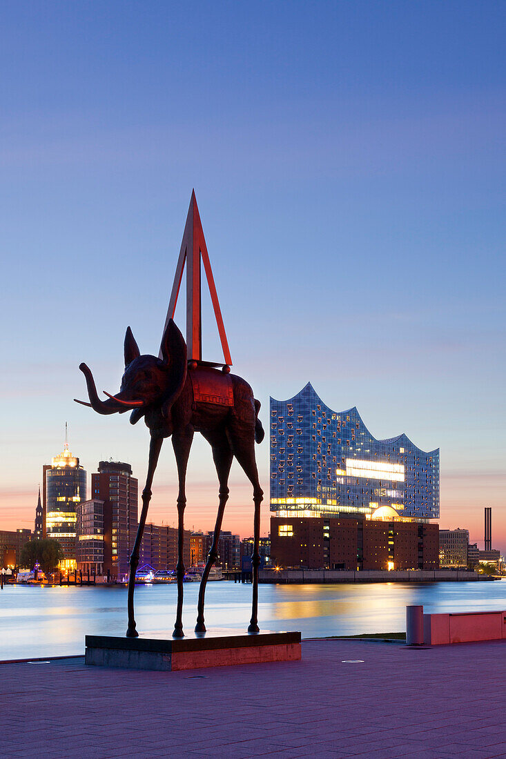 Sculpture of an elephant by Salvador Dali in front of the Stage Theatre, view over the Elbe river to the Elbphilharmonie, Hamburg, Germany
