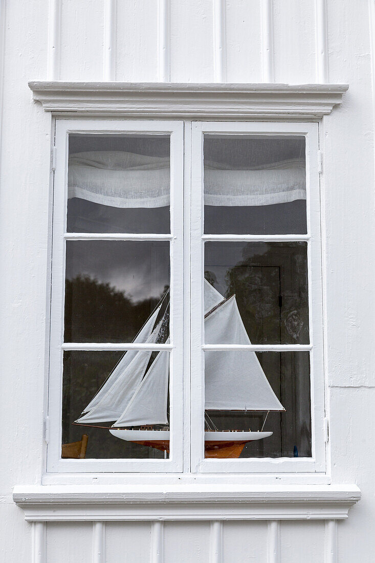 Segelboot im Fenster, weißes Holzhaus, Grundsund auf Insel Skaftö, Bohuslän, Västra Götalands Län, Südschweden, Schweden, Nordeuropa, Europa
