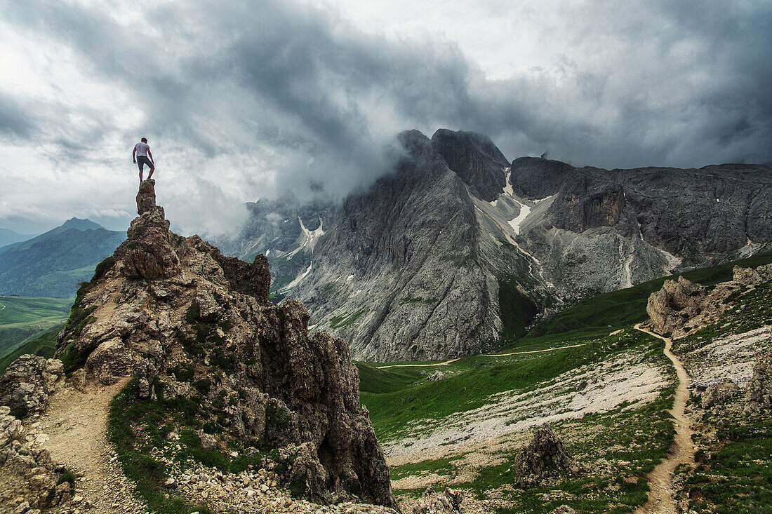Hiker enjoying venturous view in towards the Rosengarten Group, Dolomites, Unesco world heritage, Italy