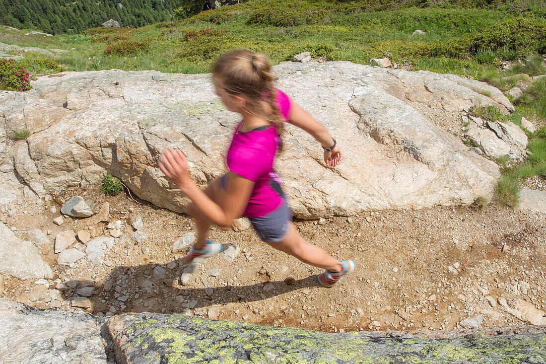 Mädchen beim Trailrunning auf einem ausgetrockneten Pfad