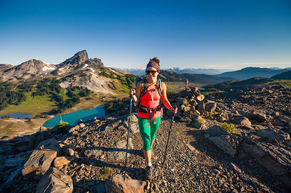 A young woman hiking on the Panorama Ridge Trail with Black Tusk Mountain in the background in Garibaldi Provincial Park, British Columbia, Canada.