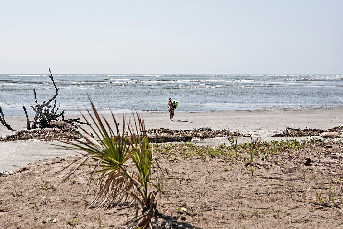 young woman carries her kayak to the water.