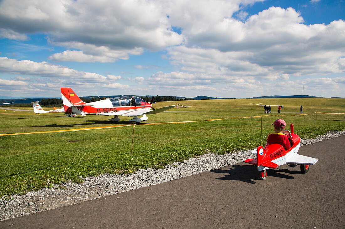 Kleiner Junge in Tretflugzeug am Kinderflugplatz neben dem Flugplatz Wasserkuppe, nahe Poppenhausen, Rhön, Hessen, Deutschland