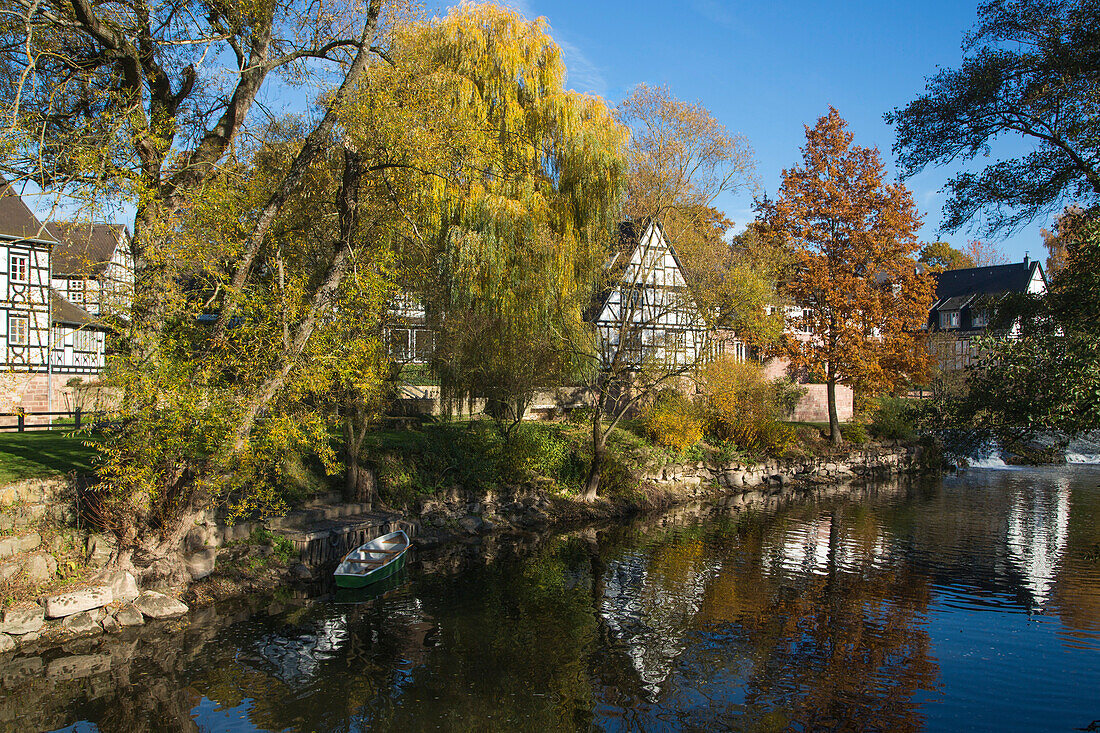 Neumühle Romantik Hotel along Fränkische Saale river and trees with autumn foliage