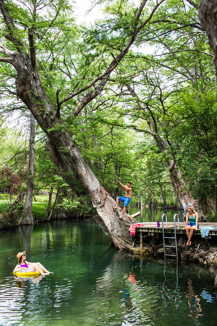 The Blue Hole in Wimberley, Texas is a popular destination for tourists and locals on hot summer days. The clear, cool water flows through cypress trees and offers a refuge from the Texas heat.
