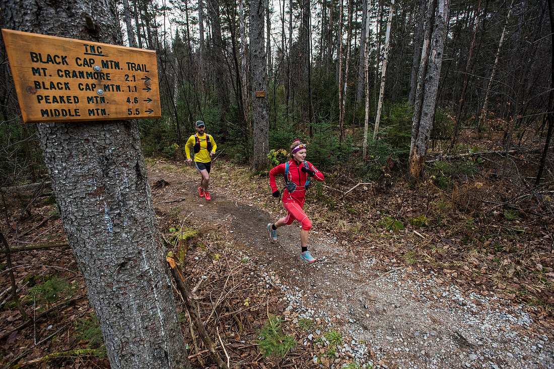 Kristina Folcik and Adam Wilcox running out of the woods on Black Cap Mt. trail.