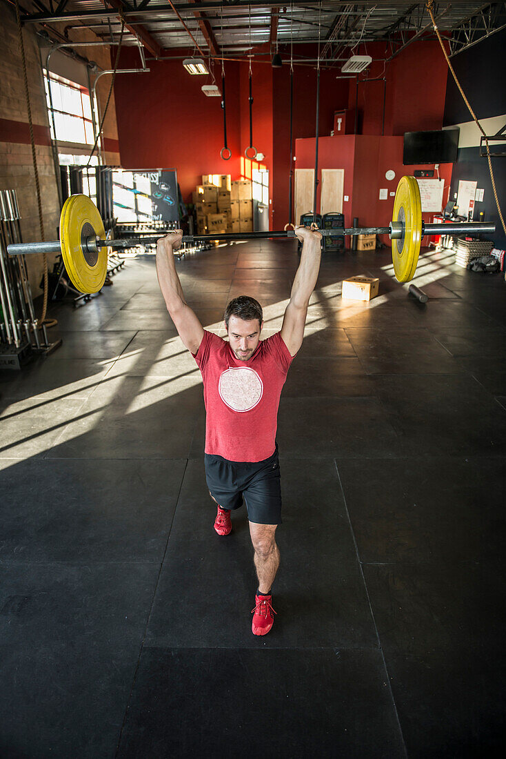 A man weight lifts at a crossfit gym.