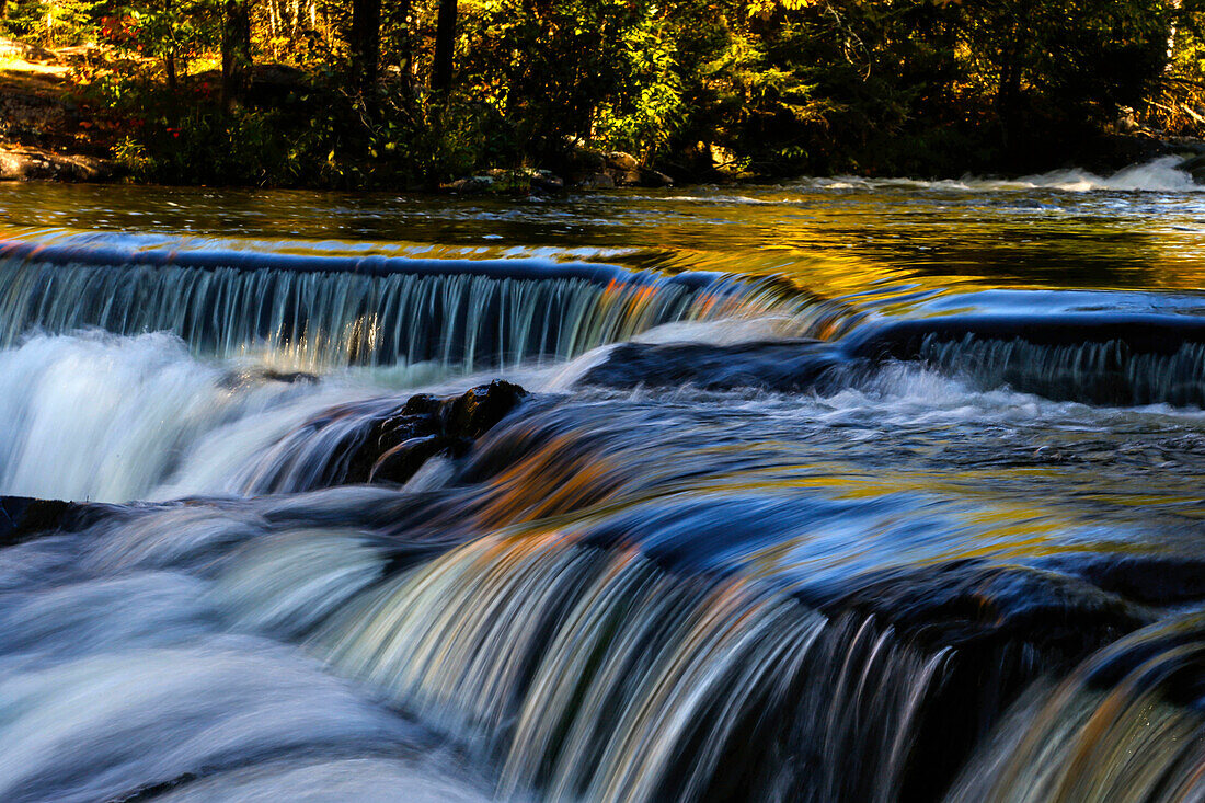Fall leaves reflect onto water in Bond Falls on the middle branch of the Ontonagon River, in Paulding, Michigan.