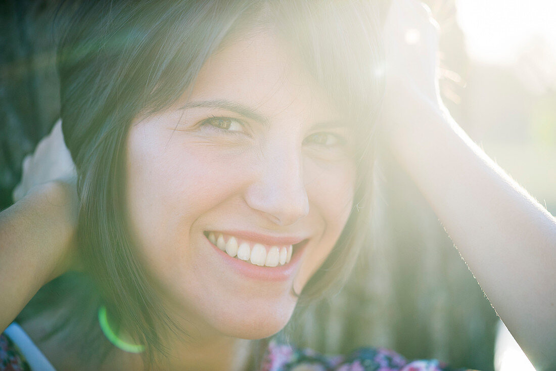 Woman smiling cheerfully outdoors, portrait