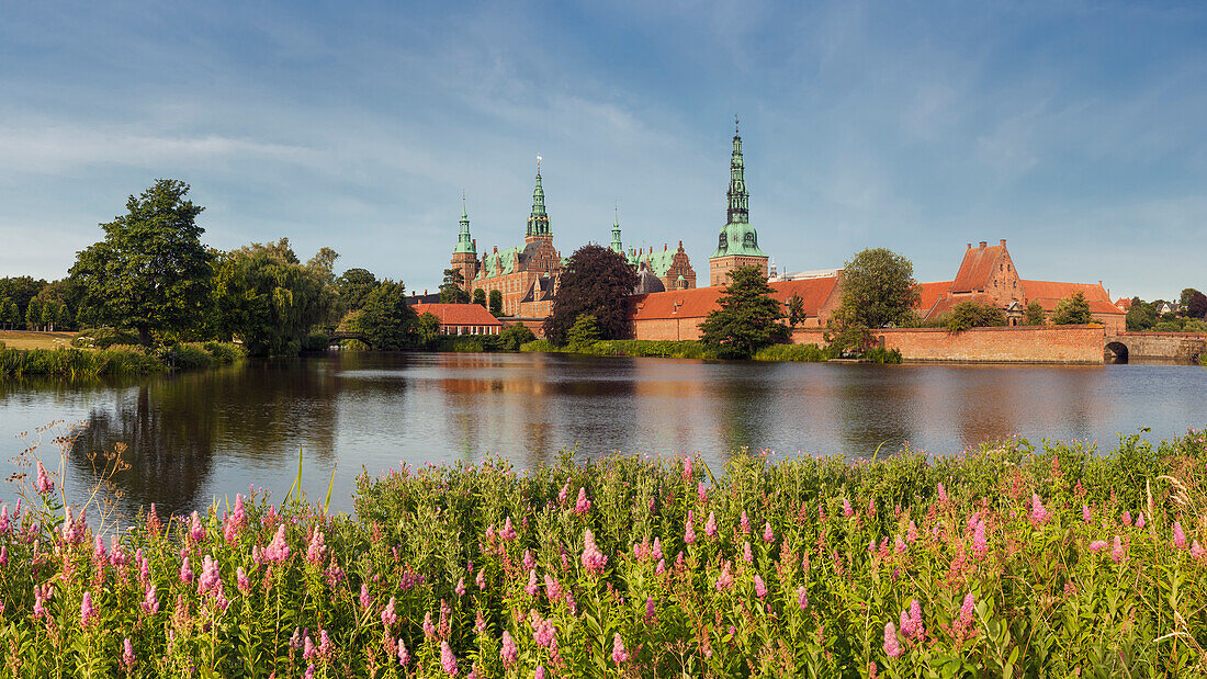 View over the lake Slotssøen to the water castle Frederiksborg on a summer day, Hillerød, Hovedstaden, Denmark