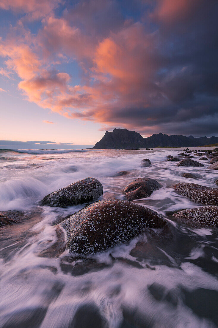 Sonnenuntergang über der Lofoten Insel Vestvågøy mit Blick auf den Strand von Utakleiv und Brandung im Vordergrund, Norwegen, Skandinavien