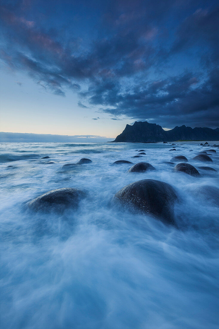 Dämmerung über der Lofoten Insel Vestvågøy mit Blick auf den Strand von Utakleiv und Brandung im Vordergrund, Norwegen, Skandinavien