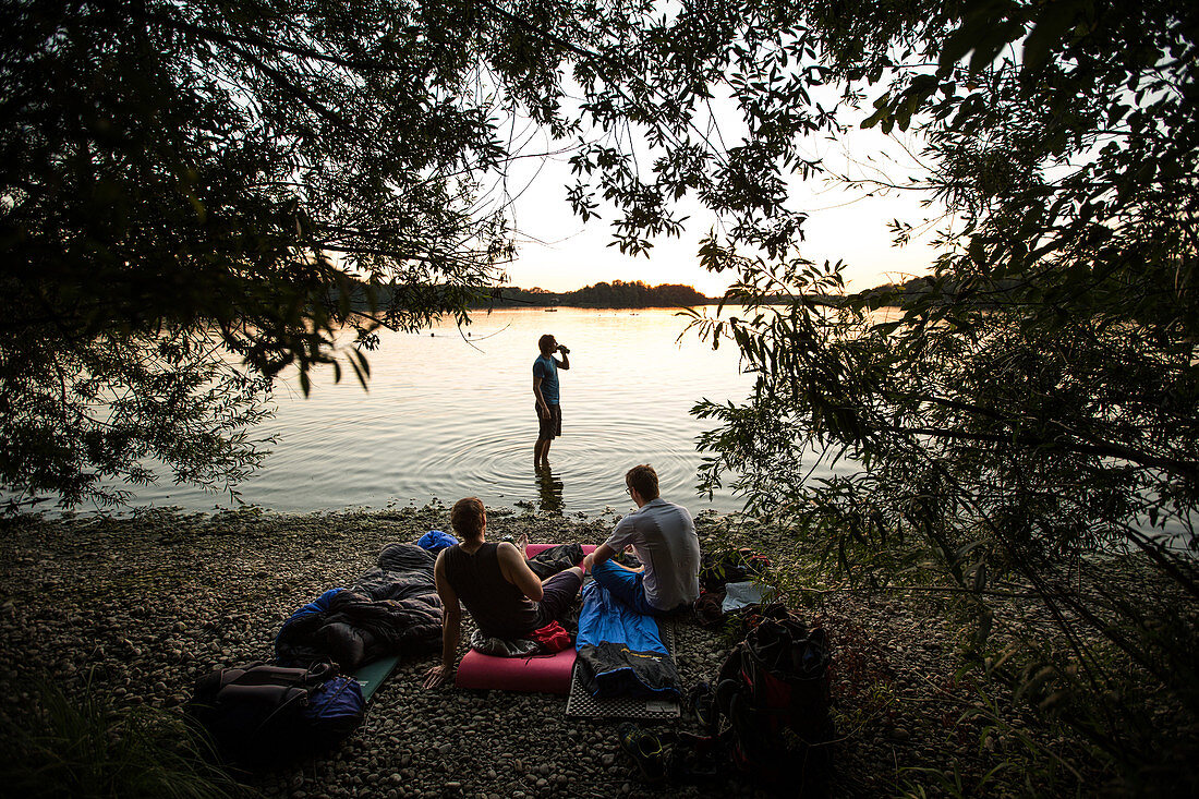Three young men camping at a lake, Freilassing, Bavaria, Germany