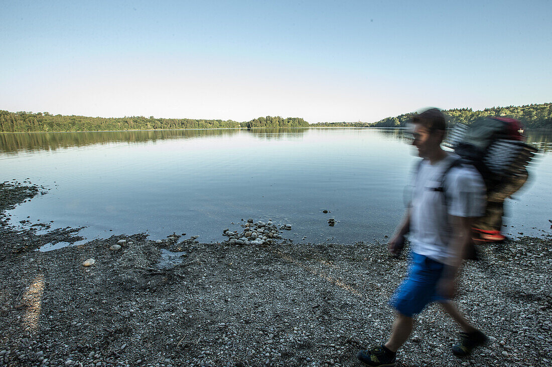 Young male camper walking at a lake, Freilassing, Bavaria, Germany