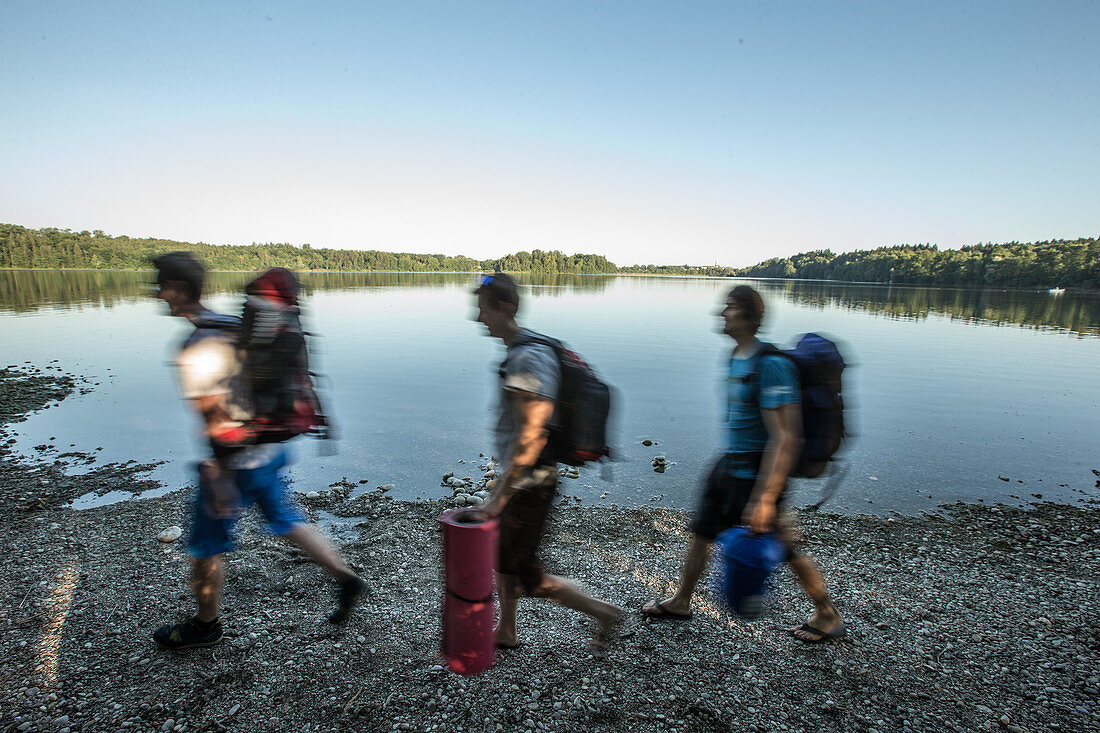 Three young male camper walking near a lake, Freilassing, Bavaria, Germany