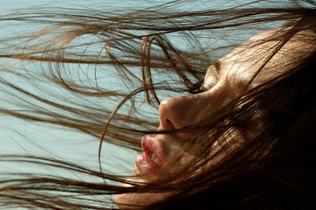 Kaukasische Frau mit im Wind wehenden Haaren
