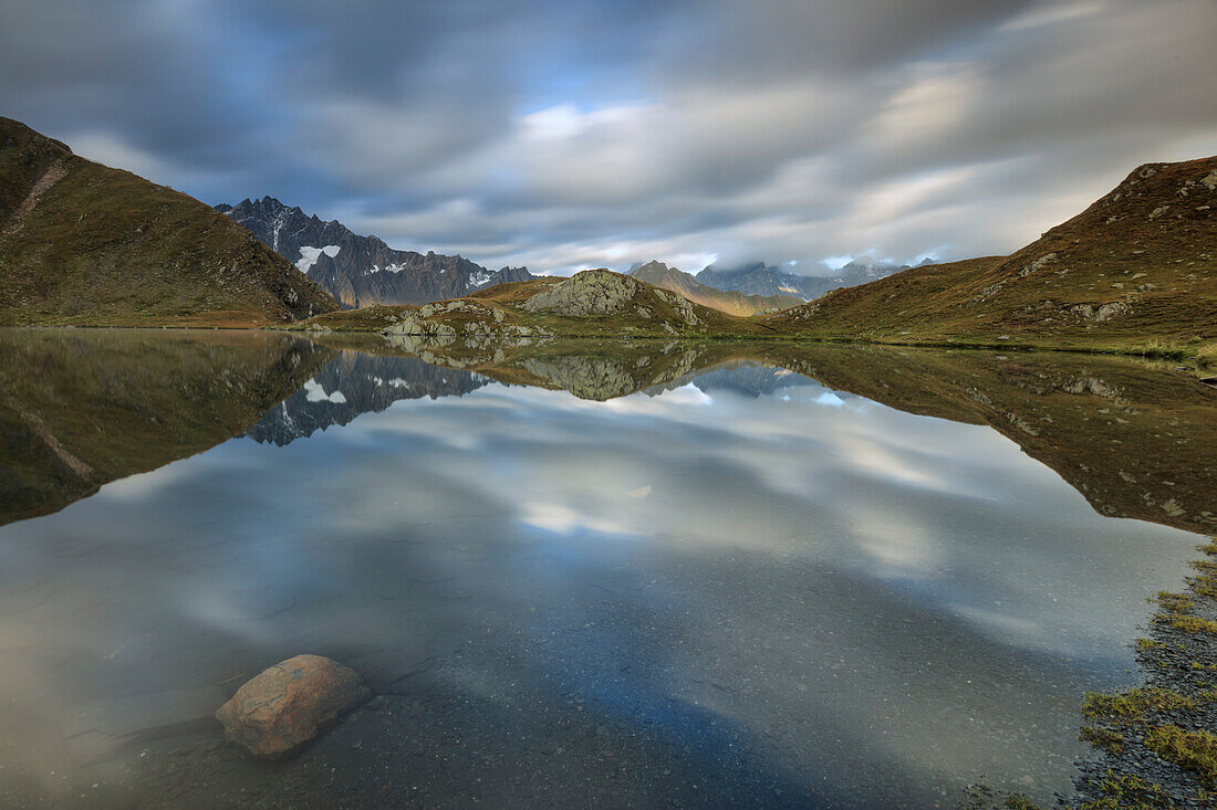The snowy peaks are reflected in Fenetre Lakes at dawn, Ferret Valley, Saint Rhemy, Grand St Bernard, Aosta Valley, Italy, Europe