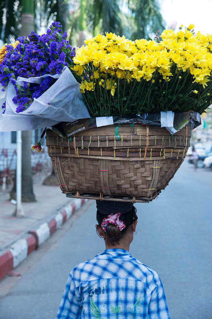 Woman carrying large flower basket on her head, Yangon (Rangoon), Myanmar (Burma), Asia
